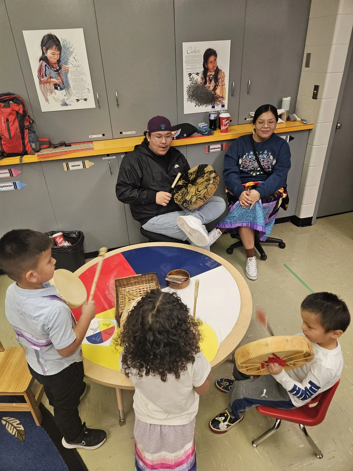 Children at the table with the two drummers seated behind them.