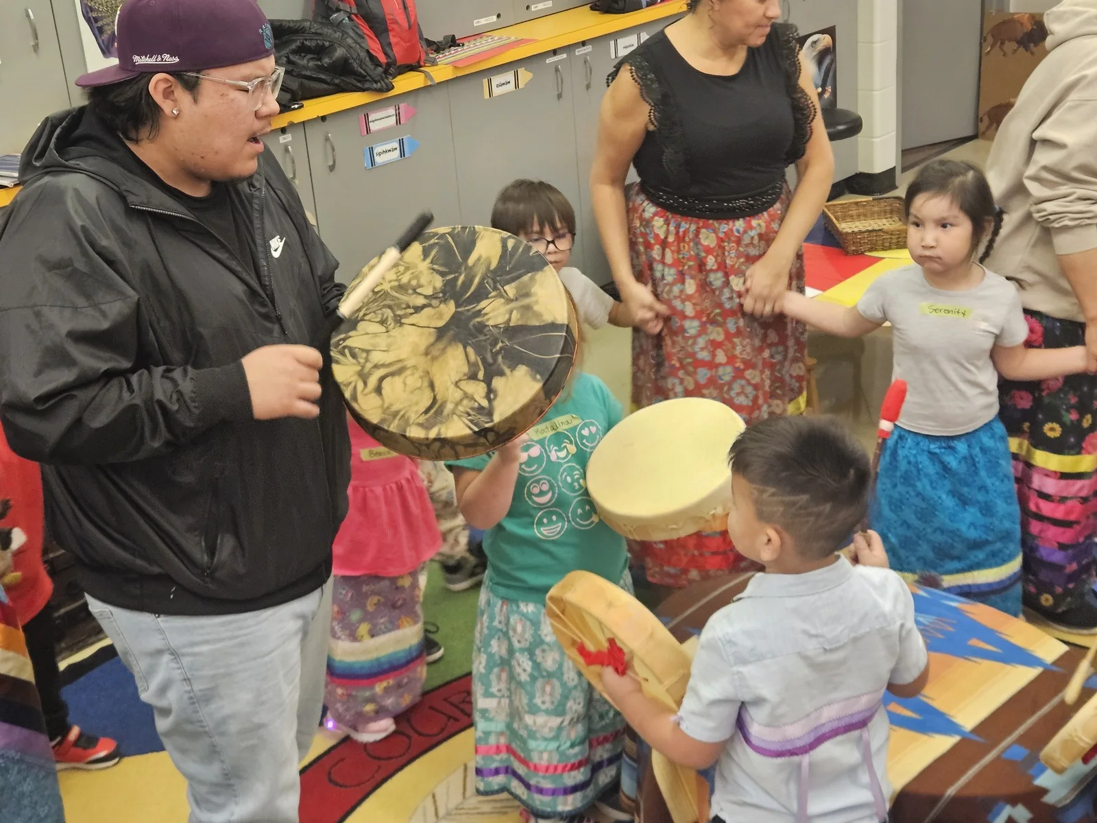 Children with their drums raised, following the beat.