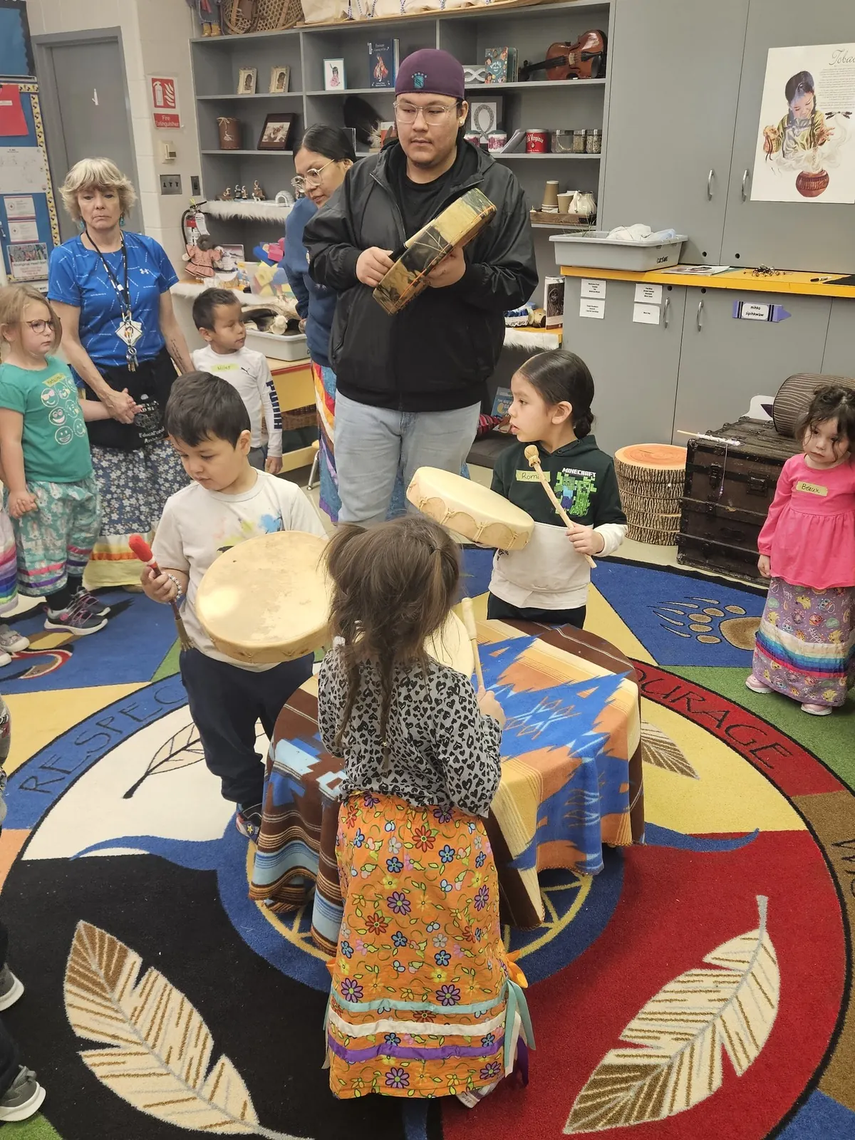 The child dancing in the centre while the others keep the drum going.