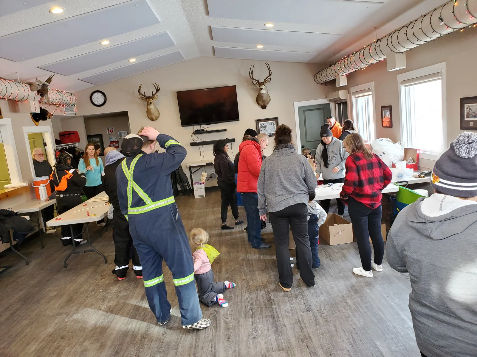 Families gathering in a hall before going out on the ice, coats on and gear being sorted.